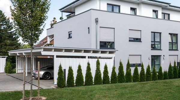 Mehrfamilienhaus mit Balkonen und begrüntem Außenbereich