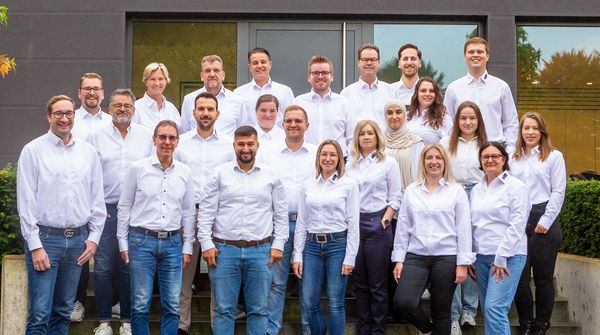 Die Mitarbeiter von Podufal-Wiehofsky stehen auf der Treppe vor dem Firmengebäude